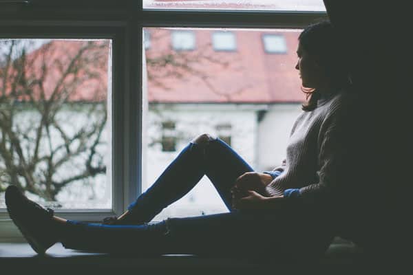 silhouette of a person sitting on the windowsill