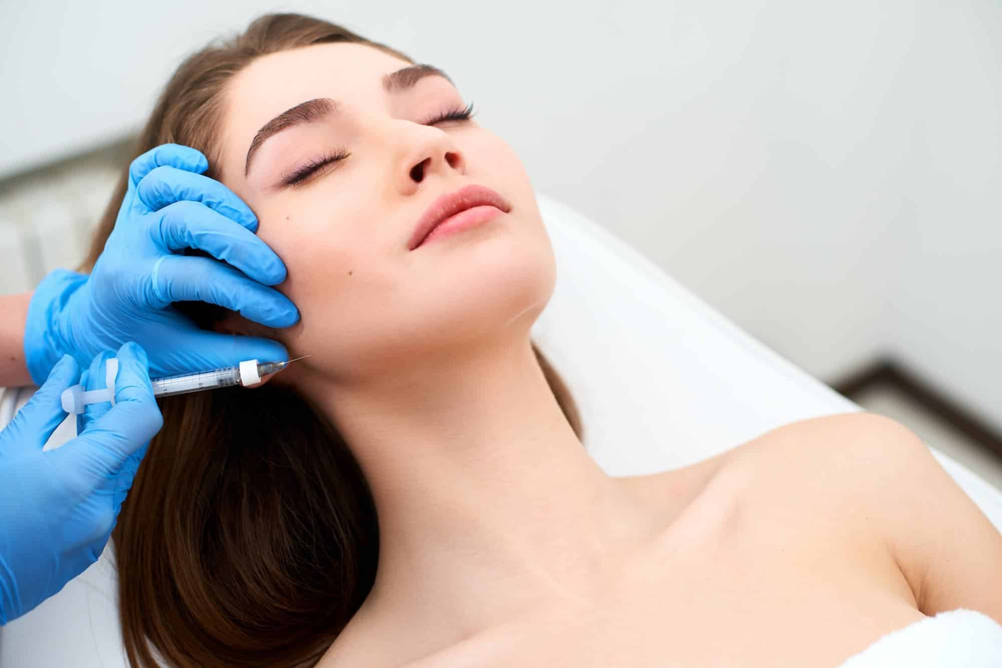 woman's face being treated by a medical professional