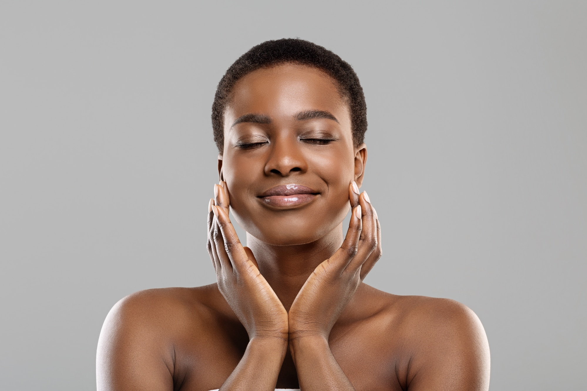 Portrait of beautiful afro girl touching her perfect skin on face