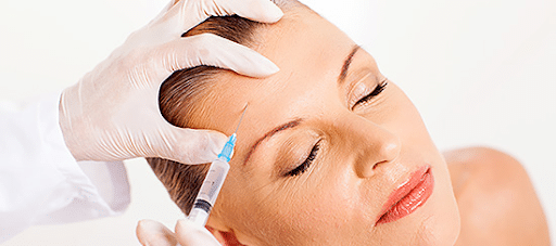 A female receiving an Aquashine treatment in a modern dermatologist's office.