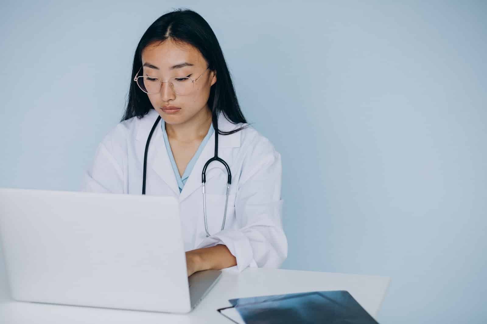 A doctor infront of a computer checking hte ordering process