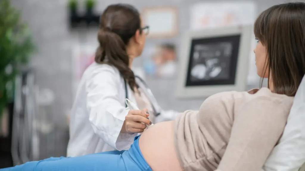 A pregnant individual undergoing an ultrasound session with their trusted medical professional.