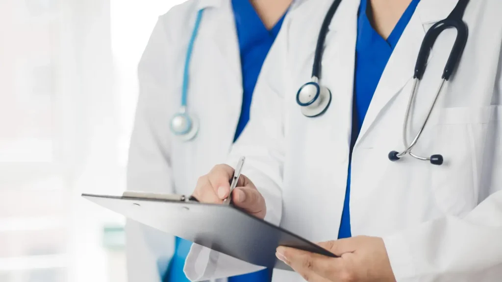 Two medical professionals preparing a recommendation for a patient after their consultation.